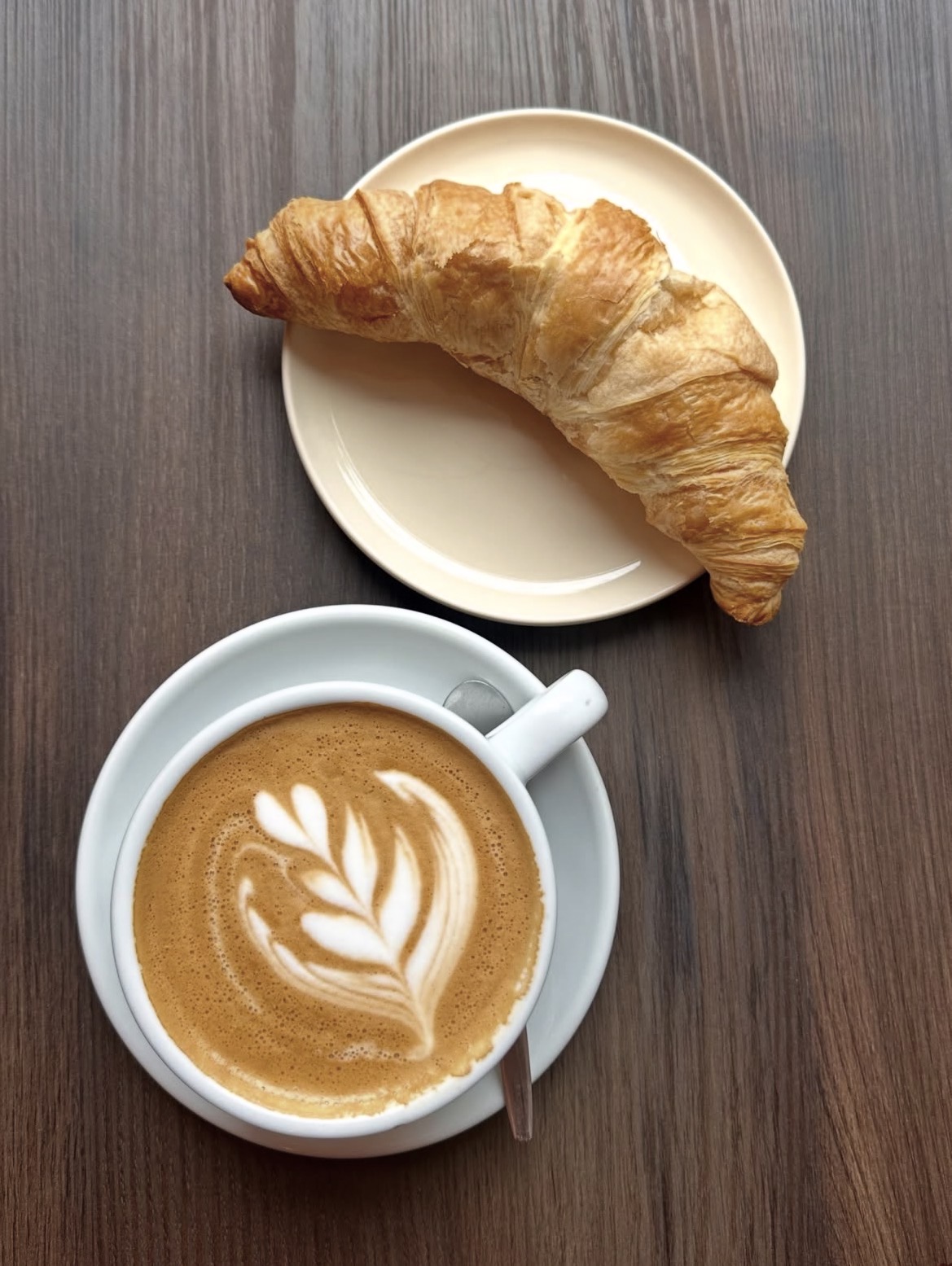 Ontbijt bij Smûk Sneek — cappuccino met latte art en een verse croissant